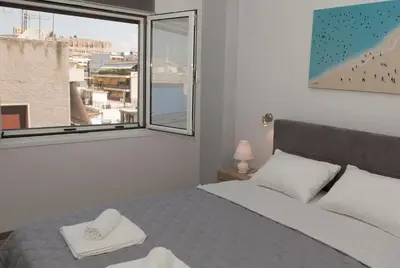 a bedroom with a bed and a large window at Acropolis Gem by GHH in Athens