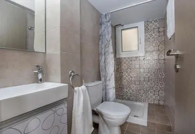 a bathroom with a toilet and a sink and a mirror at Acropolis Gem by GHH in Athens