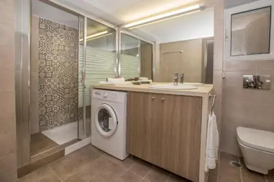 a bathroom with a sink and a washing machine at Acropolis Gem by GHH in Athens
