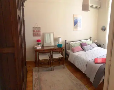 a bedroom with a bed and a desk with a mirror at Stately central apartment in Athens