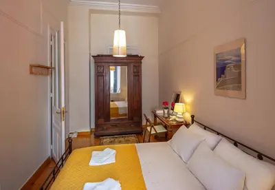 a bedroom with a bed and a table and a mirror at Stately central apartment in Athens