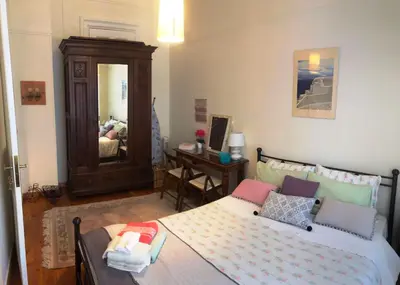 a bedroom with a bed and a desk with a mirror at Stately central apartment in Athens