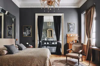 a bedroom with a bed and a chair at Bohemian Suites Athens - Maison Hotel Adults Only in Athens