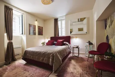 a bedroom with a bed with red pillows on it at Bohemian Suites Athens - Maison Hotel Adults Only in Athens
