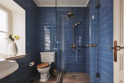 a blue tiled bathroom with a toilet and a shower at Bohemian Suites Athens - Maison Hotel Adults Only in Athens
