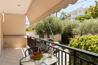 a table with a bowl of fruit on a balcony at Seaside House in Voula in Athens