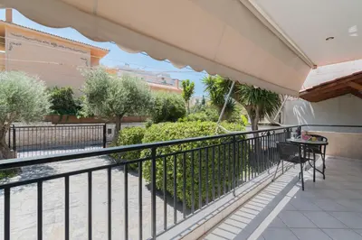 a balcony with a black railing and a table at Seaside House in Voula in Athens