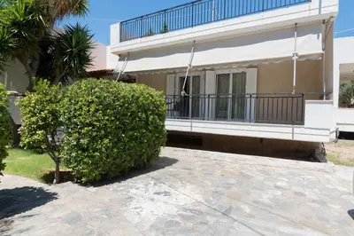 a person standing on the balcony of a house at Seaside House in Voula in Athens