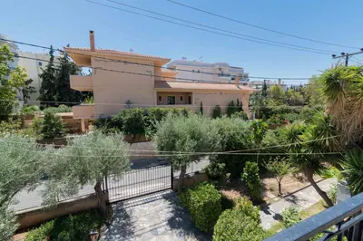 a house with a garden in front of a building at Seaside House in Voula in Athens