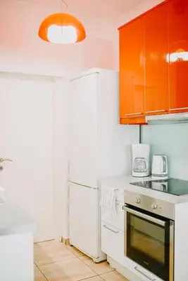 a kitchen with white appliances and orange cabinets at Best House, Rooftop Aprtm., Marina Zeas Piraeus in Piraeus