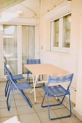 a table and chairs in a room with windows at Best House, Rooftop Aprtm., Marina Zeas Piraeus in Piraeus