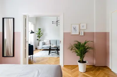 a bedroom with pink and white walls and a potted plant at Acropolis Heart 2BD Apartment in Plaka by UPSTREET in Athens