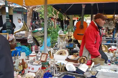 a man standing in a market with a lot of items at Stylish, Basement Studio with Roof Garden Access - EP9B in Athens
