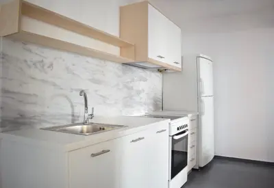 a white kitchen with a sink and a refrigerator at Stylish, Basement Studio with Roof Garden Access - EP9B in Athens