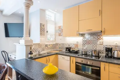 a kitchen with yellow cabinets and a yellow vase on a counter at Splash of Glam II 10 Steps from Acropolis in Athens