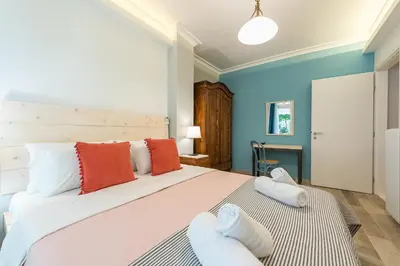 a bedroom with a large bed with orange and white pillows at Splash of Glam II 10 Steps from Acropolis in Athens