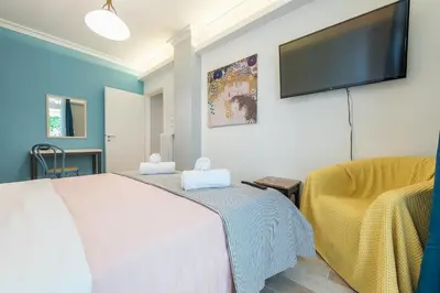 a bedroom with two beds and a flat screen tv at Splash of Glam II 10 Steps from Acropolis in Athens