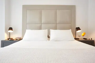 a bedroom with a large white bed with two lamps at Athenian Residences in Athens