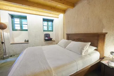 a bedroom with a bed with white sheets and a window at Athenian Residences in Athens