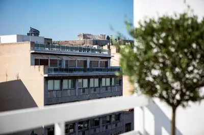 a view of a building with a tree in the foreground at Unique 3-Bed, 3-Bath Apt with Acropolis Views SG69 in Athens