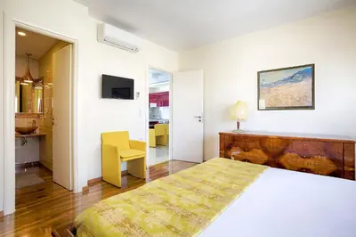 a bedroom with a bed and a table and a chair at Unique 3-Bed, 3-Bath Apt with Acropolis Views SG69 in Athens