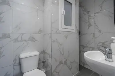 a white bathroom with a toilet and a sink at The Historical Center Studios in Athens
