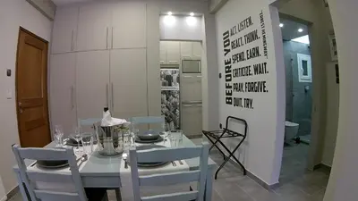 a dining room with a white table and chairs at “ZEUS”, STYLISH LUXURY BUSINESS SUITE in the heart of Athens. in Athens