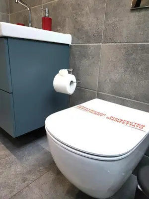 a white toilet in a bathroom with a roll of toilet paper at “ZEUS”, STYLISH LUXURY BUSINESS SUITE in the heart of Athens. in Athens