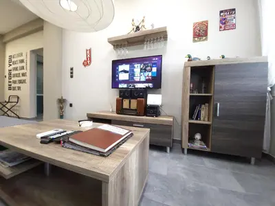 a living room with a table and a tv at “ZEUS”, STYLISH LUXURY BUSINESS SUITE in the heart of Athens. in Athens
