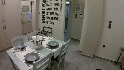 a dining room table with plates and silverware on it at “ZEUS”, STYLISH LUXURY BUSINESS SUITE in the heart of Athens. in Athens