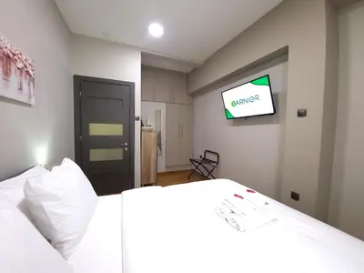a bedroom with a bed and a tv on the wall at “ZEUS”, STYLISH LUXURY BUSINESS SUITE in the heart of Athens. in Athens