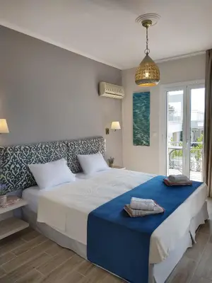 a bedroom with a large bed with a blue blanket at Lilly Apartments in Athens