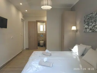 a bedroom with a white bed with towels on it at Lilly Apartments in Athens