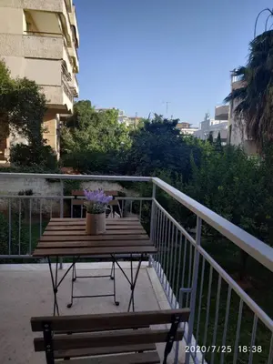 a wooden table with a potted plant on a balcony at Lilly Apartments in Athens