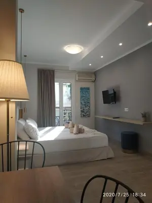 a bedroom with a large white bed and a window at Lilly Apartments in Athens