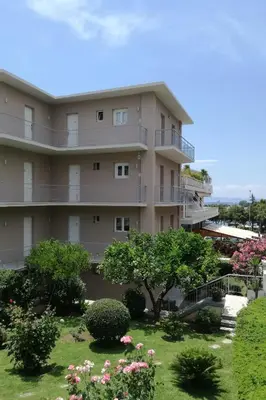 a large apartment building with a garden in front of it at Lilly Apartments in Athens