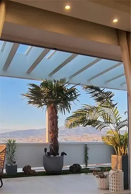 a room with a large window with palm trees at One 360 Skyline Athens Penthouses in Athens