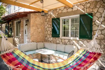 a hammock on a patio with a table and chairs at Traditional Thiseio Home in Athens