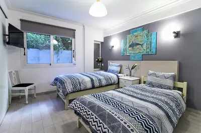 a bedroom with two beds and a television in it at Best neighbourhood apartment in Athens near metro station & hospitals in Athens