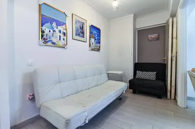 a living room with a white couch and a chair at Best neighbourhood apartment in Athens near metro station & hospitals in Athens