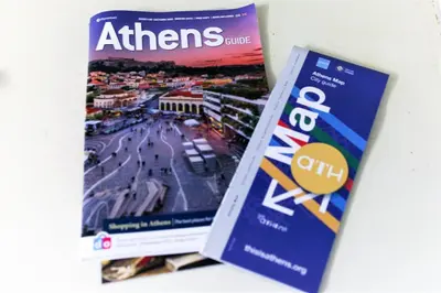 two magazines sitting next to each other on a table at Best neighbourhood apartment in Athens near metro station & hospitals in Athens
