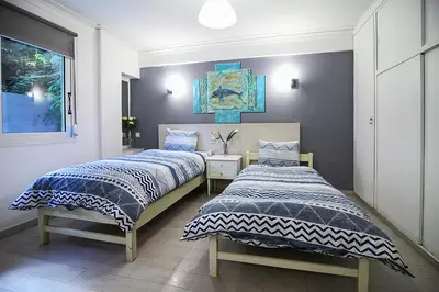 two beds sitting next to each other in a bedroom at Best neighbourhood apartment in Athens near metro station & hospitals in Athens
