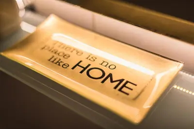 a gold object with the words there is no house like home at Photostory Art Studio in Athens