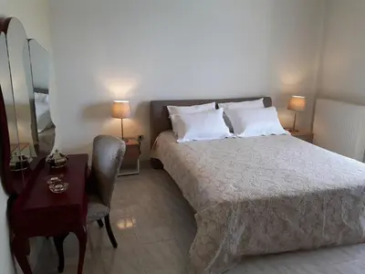 a bedroom with a bed and a table and a chair at Kalos Gialos Sunrise Apartment in Porto Rafti