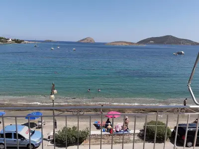 a view of a beach with people in the water at Kalos Gialos Sunrise Apartment in Porto Rafti