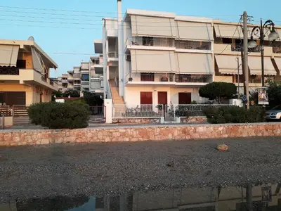 an apartment building with a reflection in a body of water at Kalos Gialos Sunrise Apartment in Porto Rafti