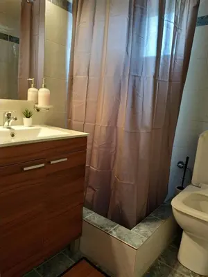 a bathroom with a sink and a shower curtain at Vravrona Artemis Home & Transfer Airport in Artemida