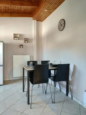 a dining room with a table and chairs and a clock at Vravrona Artemis Home & Transfer Airport in Artemida