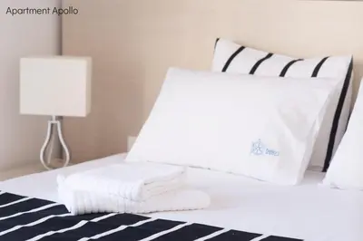 a white bed with two pillows and a lamp at Apollo & Artemis by Heloni Apartments in Athens