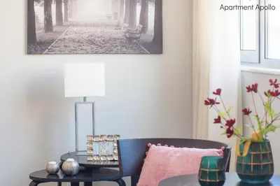 a living room with a blue couch and a table at Apollo & Artemis by Heloni Apartments in Athens